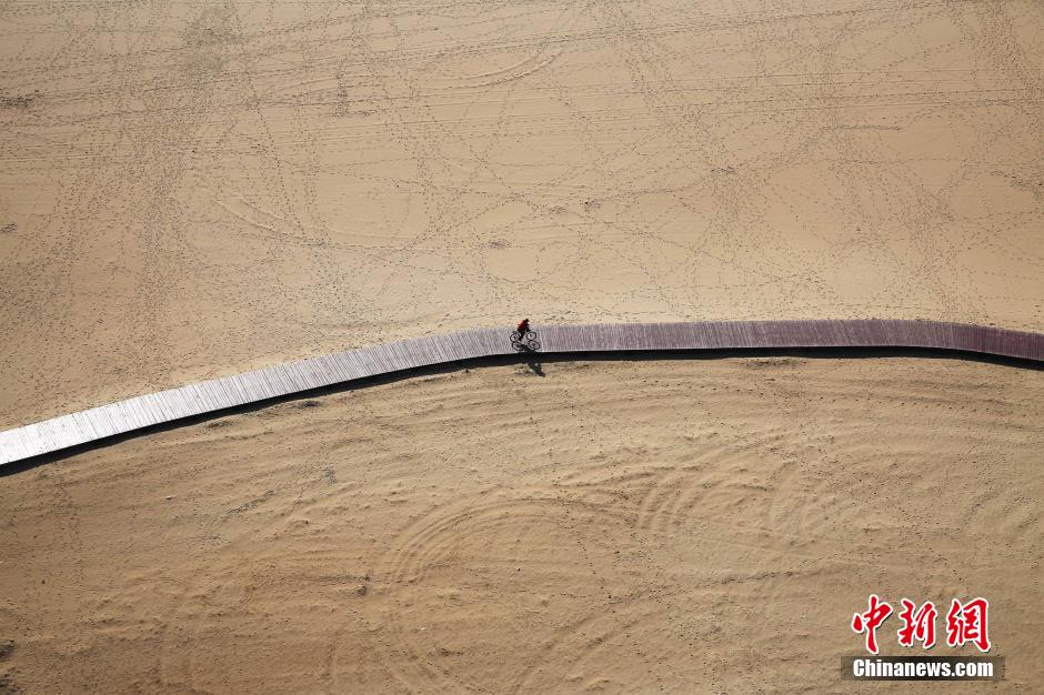 3月13日，秦皇島萬米臨海沙灘木棧道。據(jù)了解，該木棧道全長約4200米，與北戴河區(qū)原有的7500米木棧道對接后全線總長度1.17萬米，整個木棧道東起秦皇島體育基地游船碼頭，西至北戴河濕地公園，呈波浪形蜿蜒10.4公里海岸線。 中新社發(fā) 曹建雄 攝 CNSPHOTO